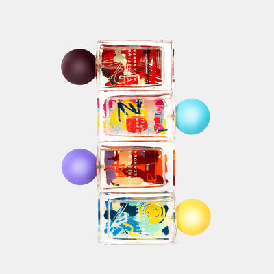 Stack of Perfume bottles with colorful labels on a white background